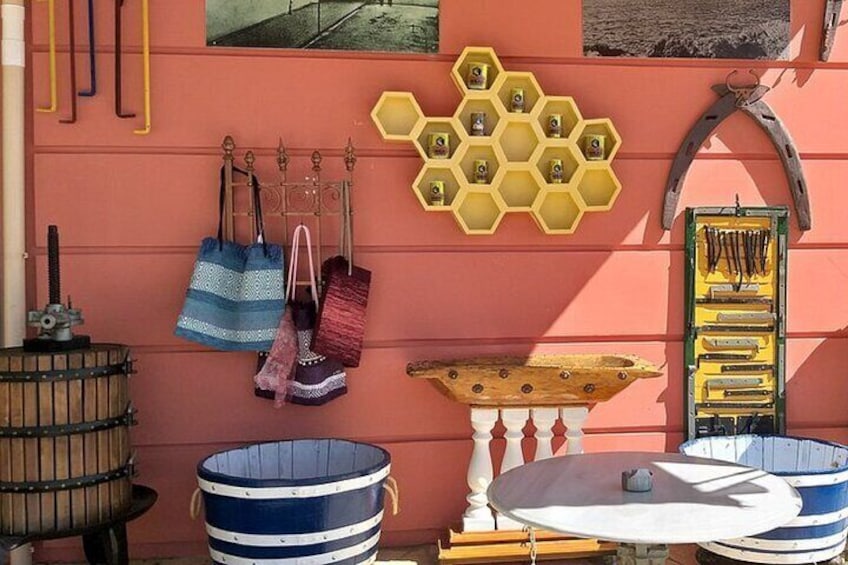Un mur orné de sacs suspendus, une décoration en forme de nid d’abeilles et un tonneau en bois. 2