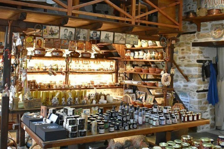 A rustic shop with wooden shelves filled with pottery and jars. 2