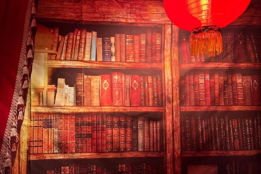 Ein Bücherregal voller Bücher, ein roter Laternenhänget und eine Holzwand. 2