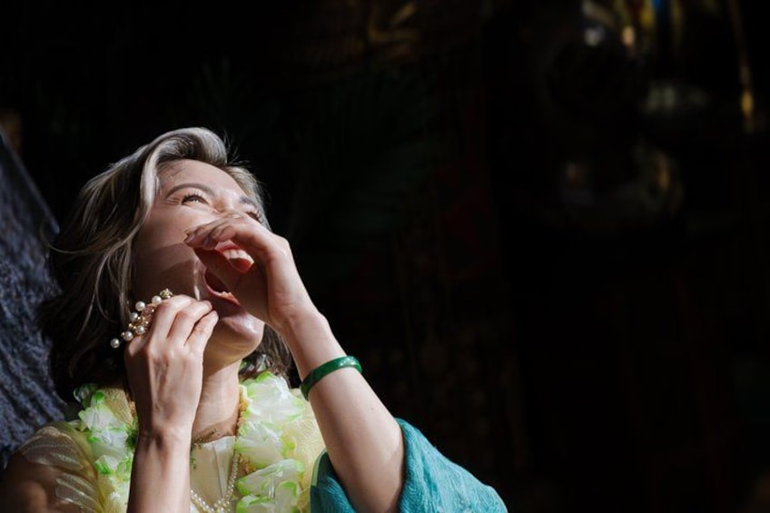 A person wearing a floral dress with a green bracelet. 4