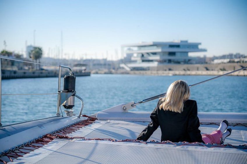 Een persoon op een zeilboot, met een stadsgezicht op de achtergrond. 3