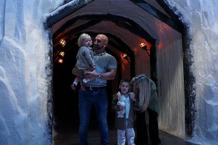 A tunnel with snow on the walls and a person holding a child. 2