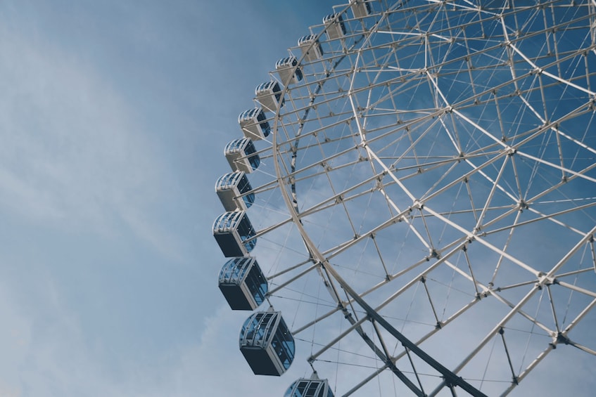 A Ferris wheel with multiple cabins against a clear sky. 4