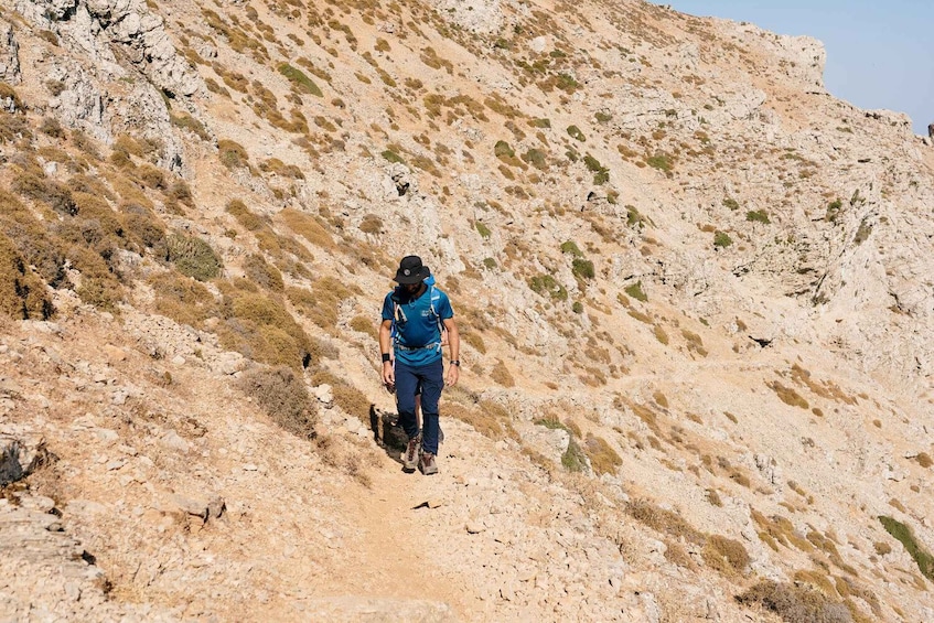 Una persona caminando por una ladera rocosa. 3