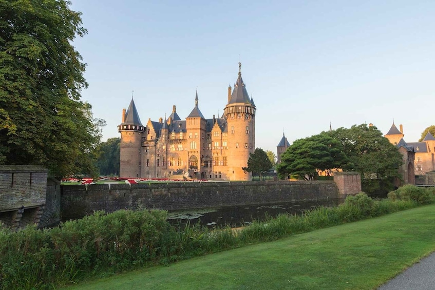 A historic castle with multiple towers, a moat, and a well-maintained lawn. 3