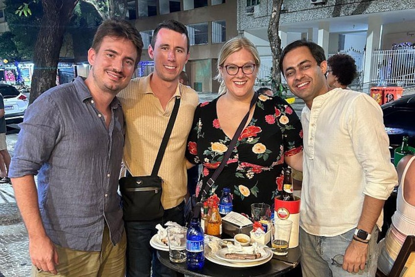 A group of people standing around a table with food and drinks. 3