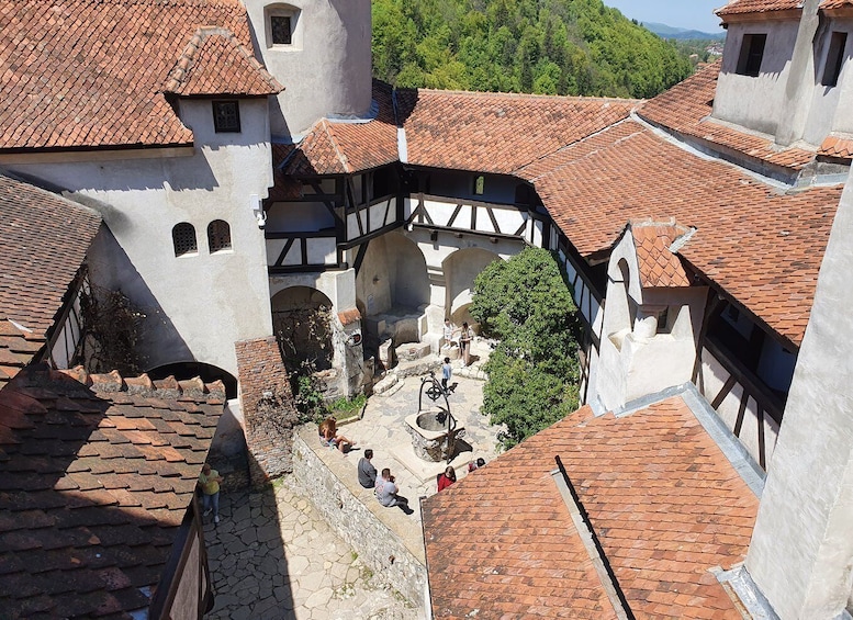 Una plaza medieval con calles empedradas, edificios tradicionales de entramado de madera y un arco central. 2