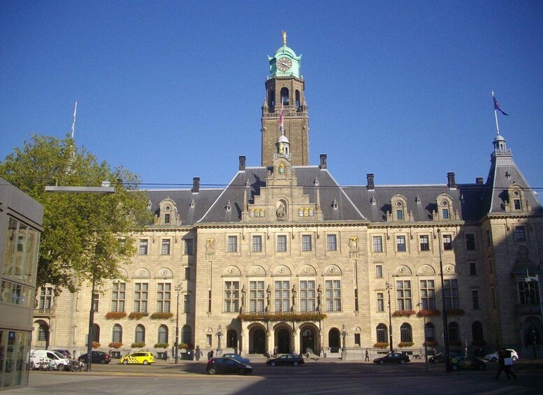 A historic building with a prominent clock tower and statues. 2