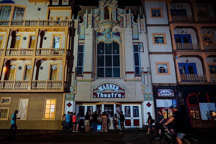 A theater with ornate architecture and a crowd of people outside. 3