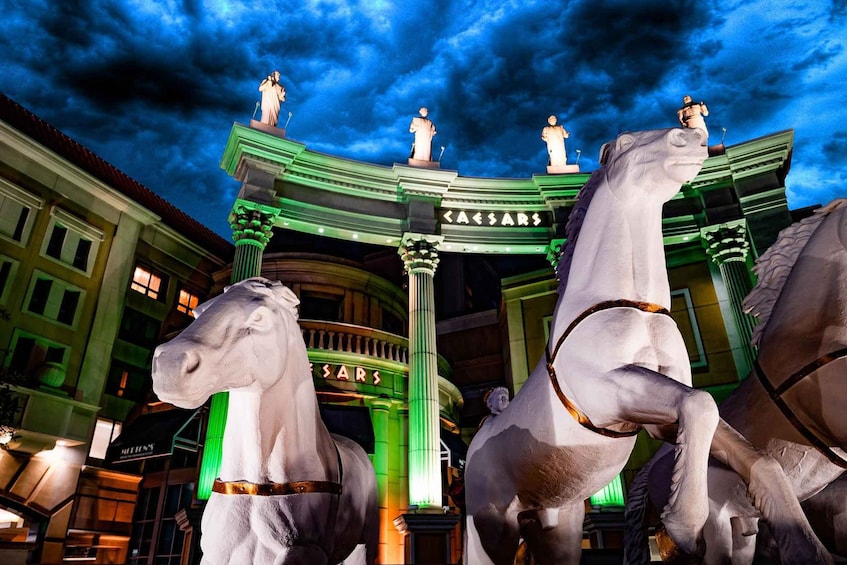 A grand entrance with two statues of horses and a sign that reads 'Caesars.' 2