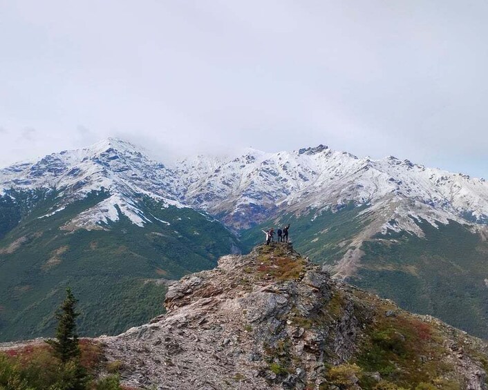 A rocky mountain peak with snow-capped mountains in the background. 3