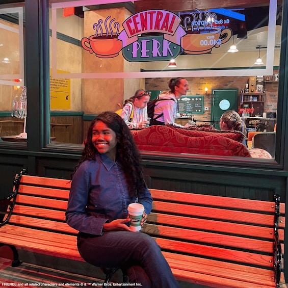 Henkilö istuu penkillä kahvilan ulkopuolella. Kahvilan nimi on »Central Perk». 3