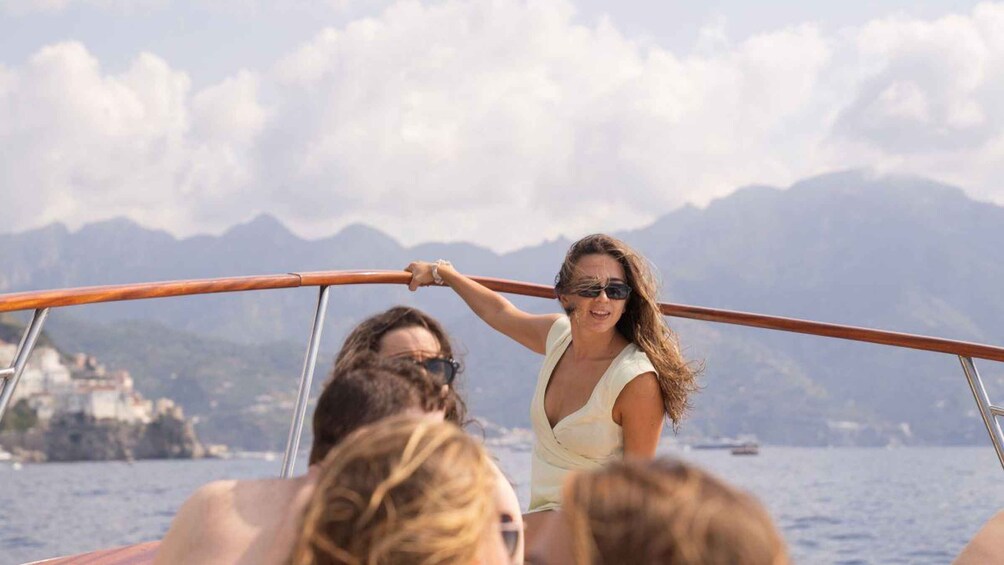 A woman on a boat with a mountainous landscape in the background. 4