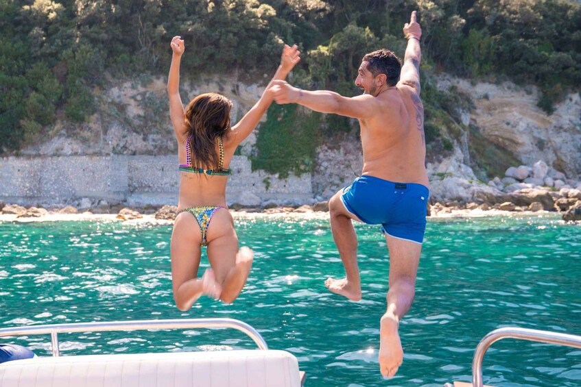 Two people jumping into the water from a boat. 3