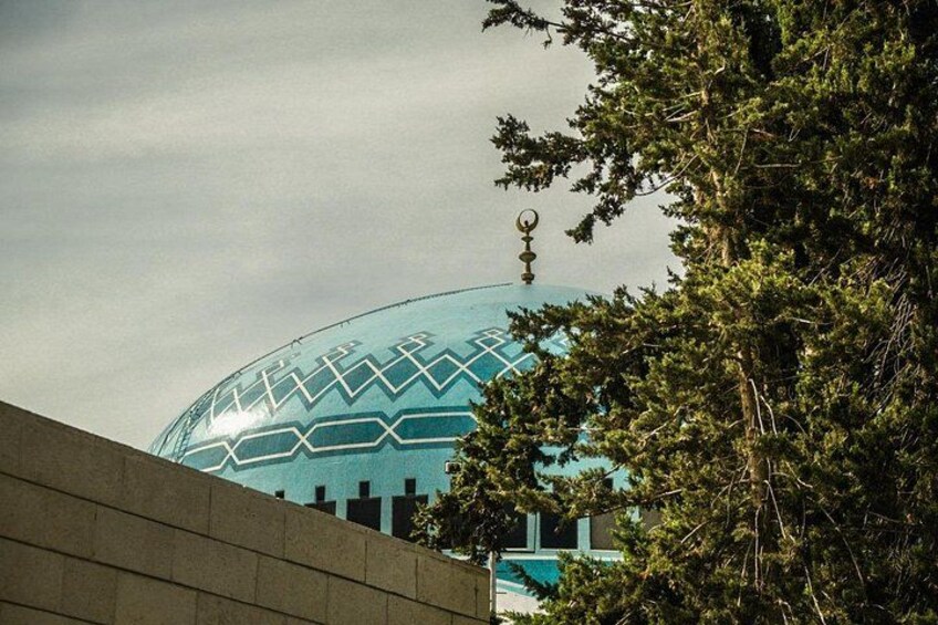A large blue dome with geometric patterns, surrounded by trees. 5