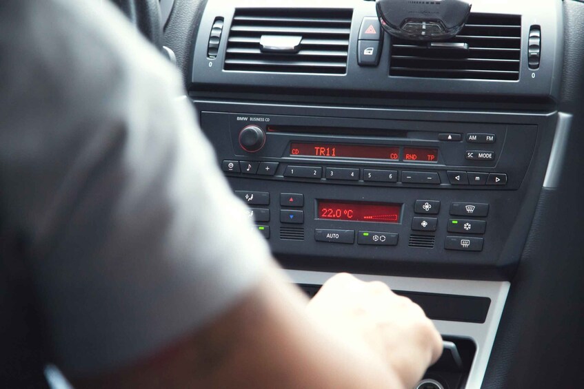 Het dashboard van een auto, met een radio waarop 'TR11' staat en een temperatuur van '22,0°C'. 3