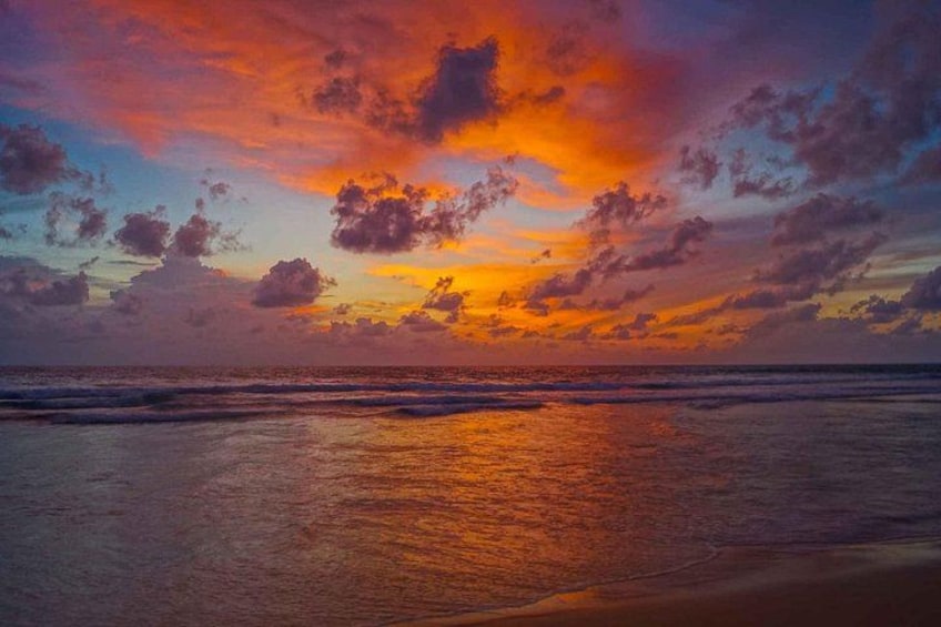 A sunset over a beach with waves and a colorful sky. 2