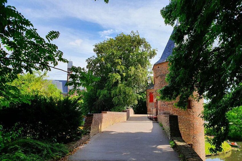A brick building with a red door, a paved pathway, and lush greenery. 5