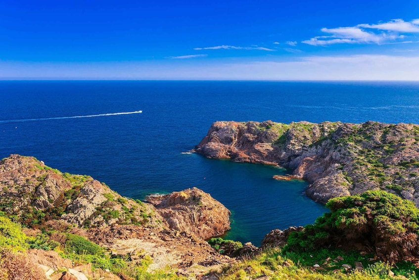 A coastal landscape with rocky cliffs and a clear blue sea. 1