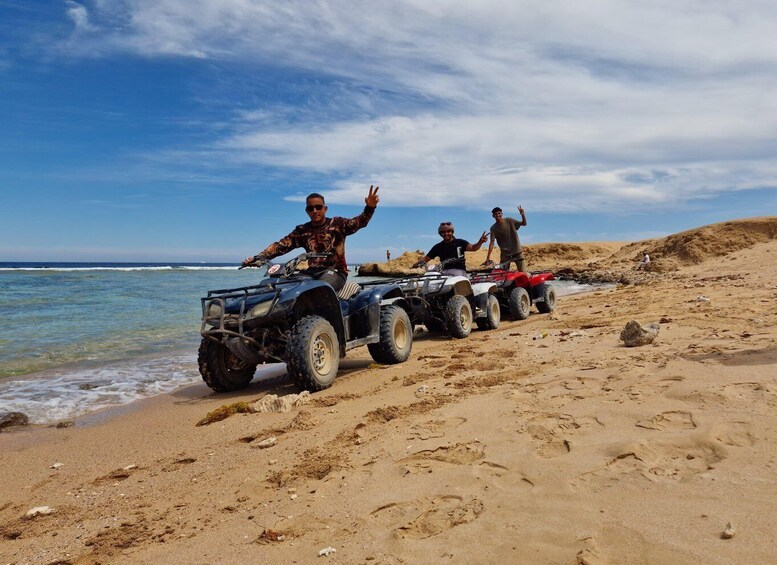 Tre ATV'er på en sandstrand med havet i baggrunden. 5