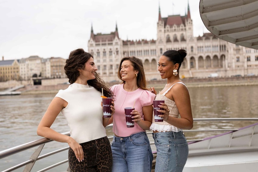 Three women on a boat with a historic building in the background. 4