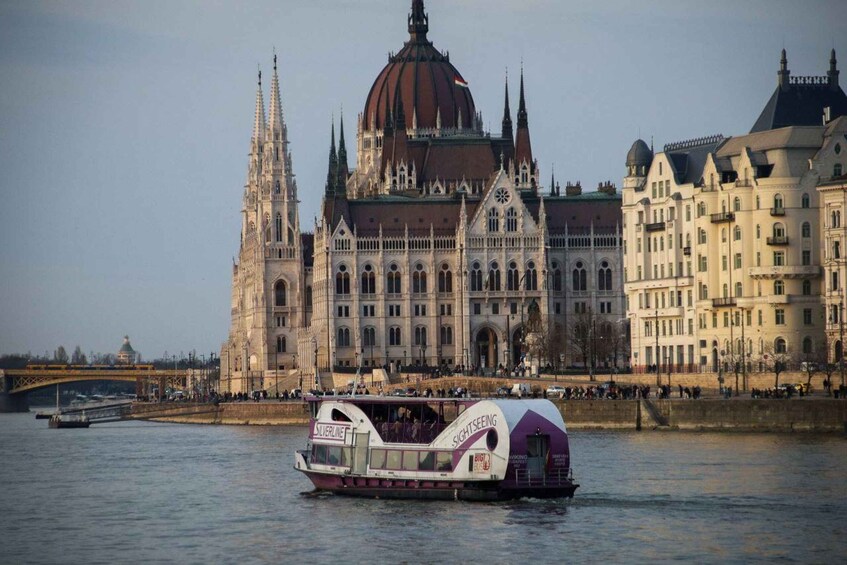 A riverboat with 'SIGHTSEEING' and 'SILVERLINE' on its side, a large ornate building with a dome, and a bridge in the background. 3