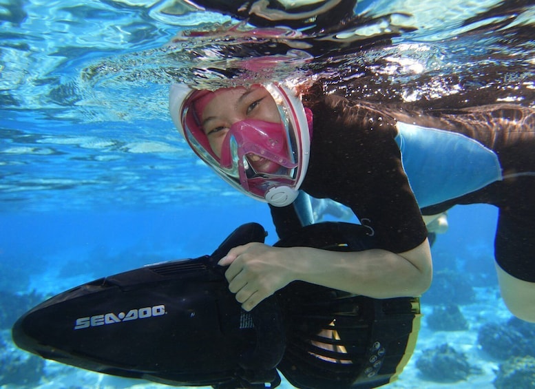 A person underwater holding a Sea-Doo personal water vehicle. 5