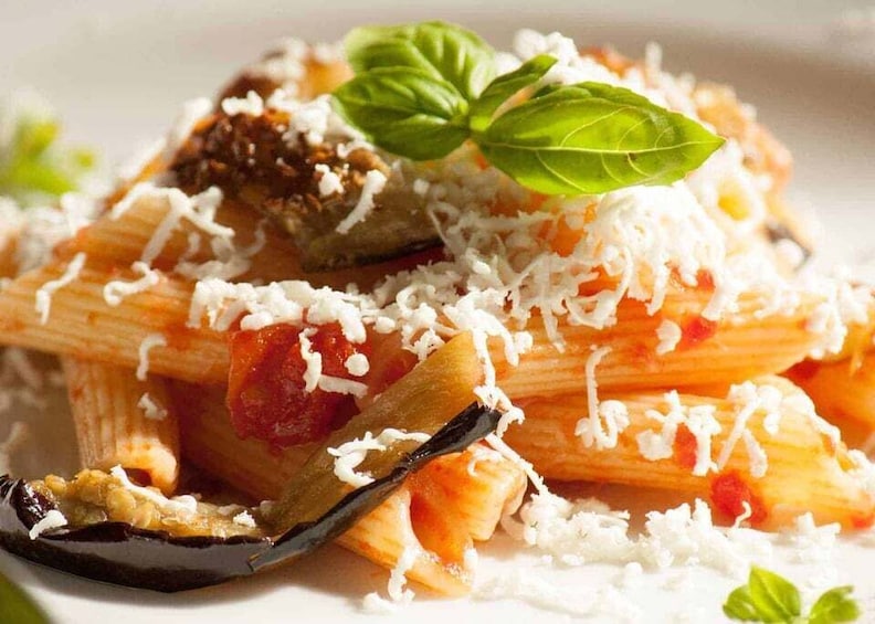 A plate of pasta with tomato sauce, cheese, and basil. 5