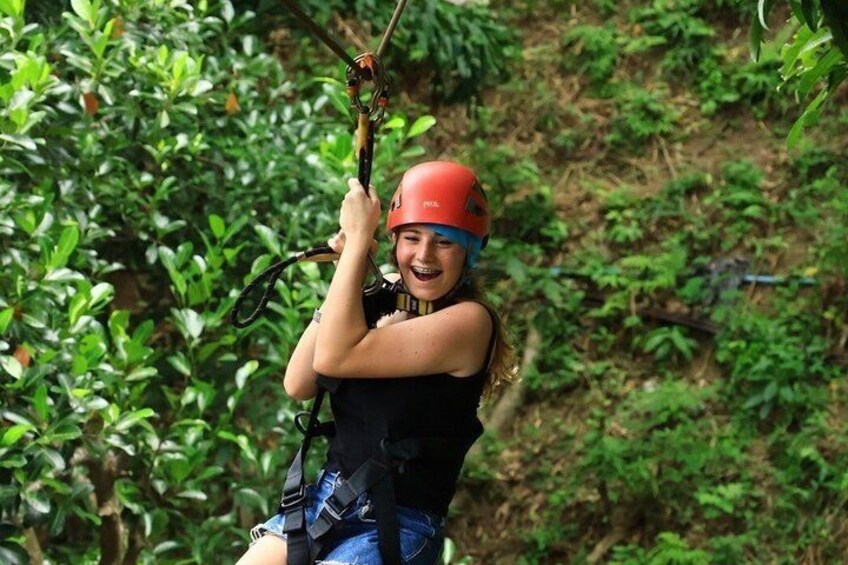 En person som åker på en zipline genom ett skogsområde. 4