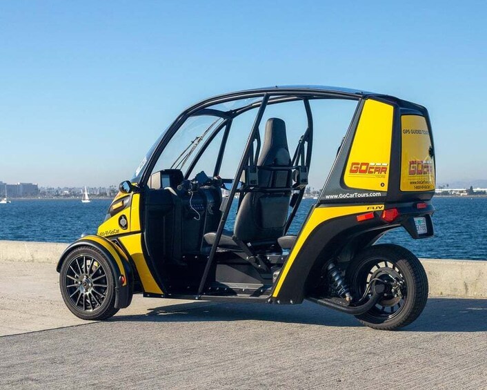 A yellow and black electric vehicle parked by a waterfront. 3