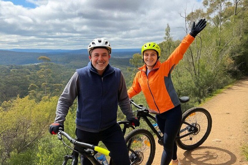 Två personer på en mountainbikeled med en vacker utsikt över landskapet. 2