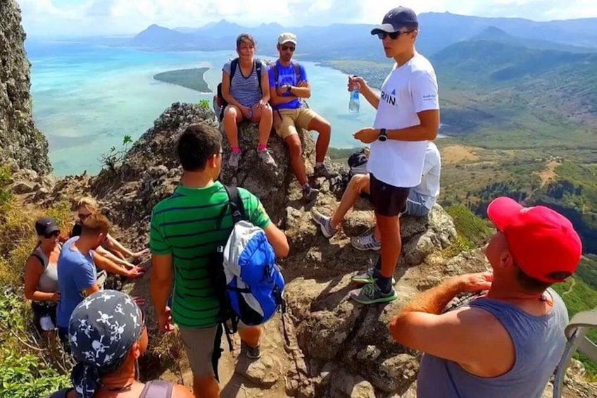 Un grupo de excursionistas en un sendero de montaña, con vistas a un paisaje costero. 3