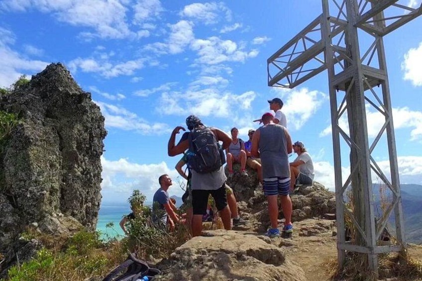 Un grupo de excursionistas en un sendero pedregoso bajo un cielo despejado y con vista al océano. 4
