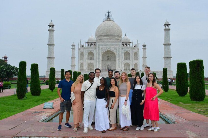 A group of people posing in front of the Taj Mahal. 2