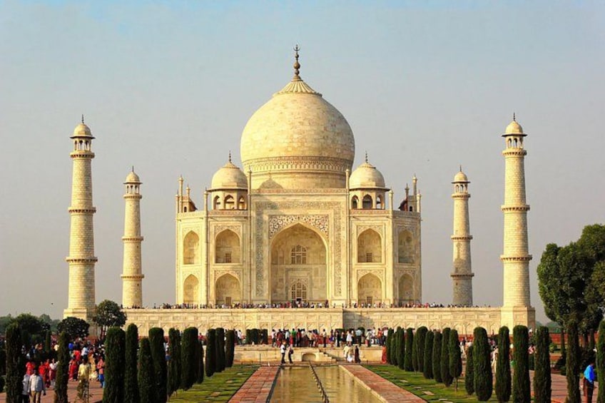 The Taj Mahal with four minarets, a large central dome, and a symmetrical garden with a reflecting pool. 5
