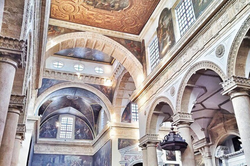 Un intérieur caractérisé par des plafonds en arc de cercle, des colonnes et des fresques ornées. 2