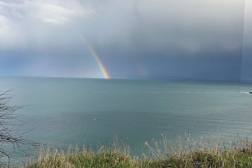 Une mer calme, avec un arc-en-ciel à l’horizon. 3
