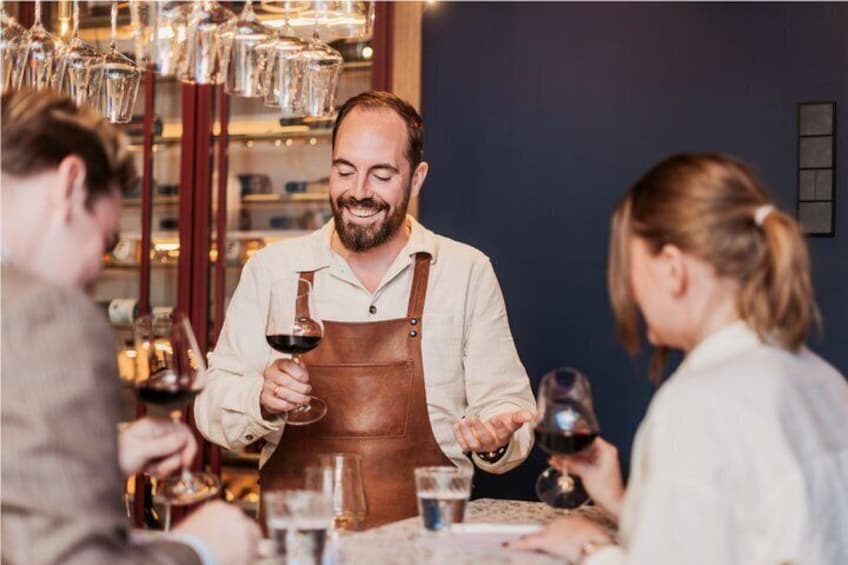 A person serving wine to customers at a bar. 1