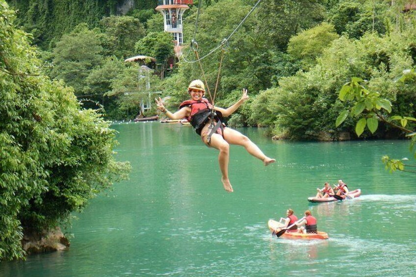 A person bungee jumping from a bridge over a river surrounded by lush greenery. 5