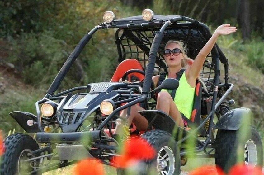 A person in a buggy with a canopy, large wheels, and headlights. 4