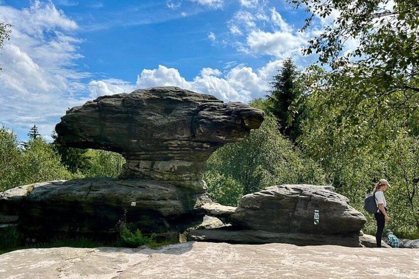 A natural rock formation with a person standing nearby. 2