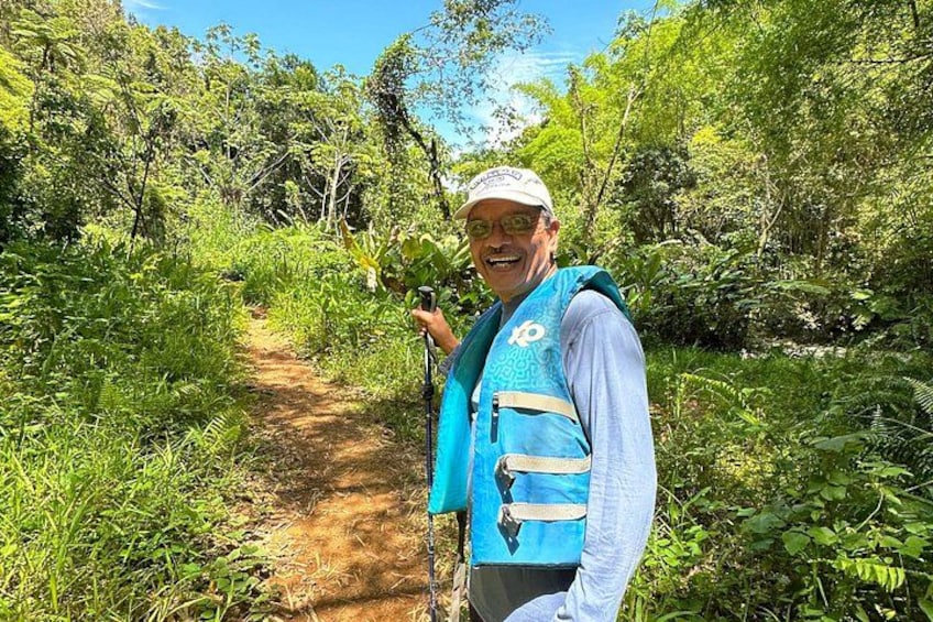 Una persona caminando por un sendero de tierra rodeada de abundante vegetación. 3