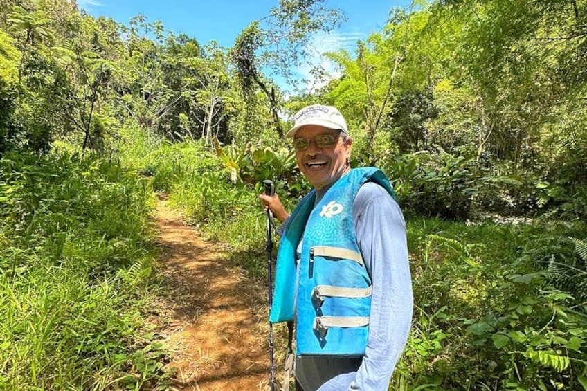 Una persona caminando por un sendero de tierra rodeada de abundante vegetación. 2