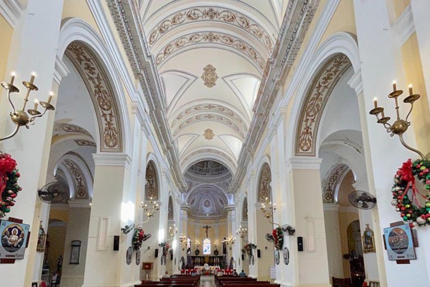 An ornate church interior with high ceilings, arched columns, and decorative moldings. 2