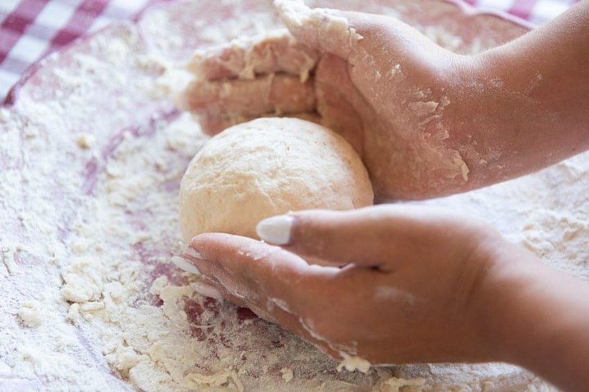 Hands kneading dough on a floured surface. 5