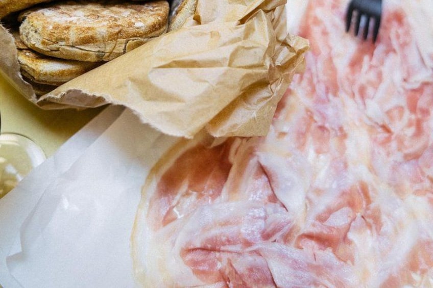 A paper bag with bread and a piece of meat. 5