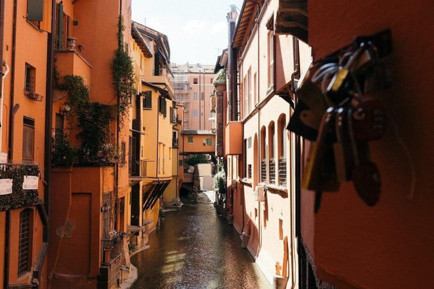 A narrow waterway flanked by buildings with balconies and a row of keys hanging on a wall. 2