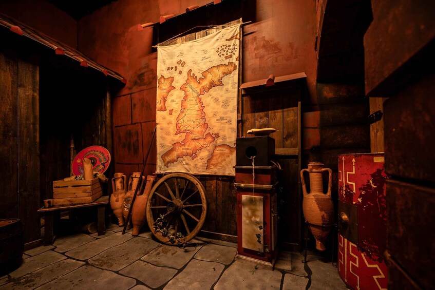 An antique map, pottery, and a wooden cart wheel in a rustic setting. 4