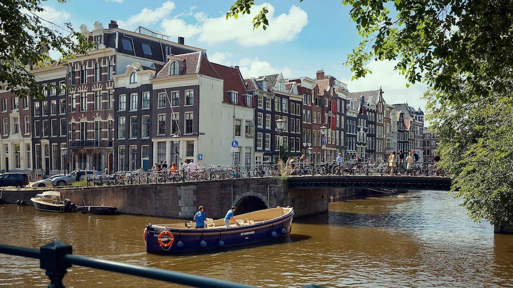 A canal with a boat named 'Starboard' and a bridge with people and bicycles. 5