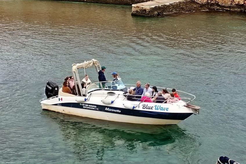 A boat named 'Blue Wave' with passengers on a calm body of water. 4